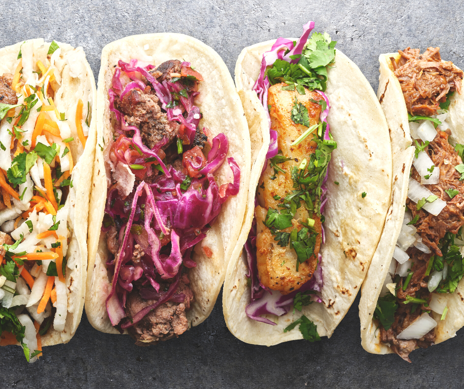 tacos of different kinds lined up side by side ready to eat